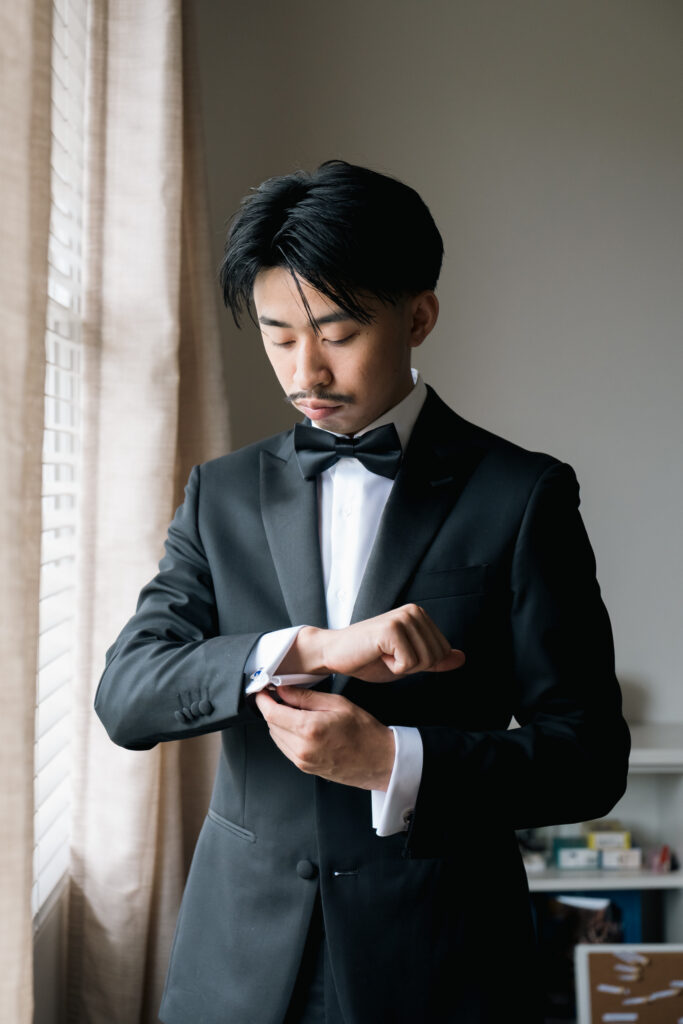 Groom getting ready on his wedding day, adjusting his suit before the ceremony in Sydney.